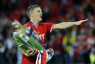 Bastian Schweinsteiger holding the trophy