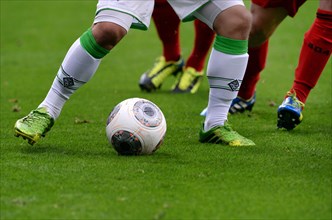 Legs of players from Borussia Moenchengladbach and Bayer Leverkusen with a ball