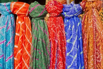 Colourful silk scarves are displayed for sale