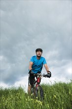 Man riding a mountain bike across a meadow