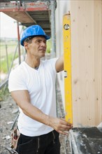 Construction manager controlling the window installation with a spirit level