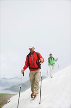 Couple moving over a snow field during their hike to Mt. Neunerkoepfle