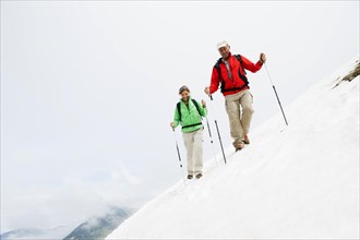Couple moving over a snow field during their hike to Mt. Neunerkoepfle