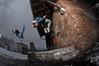 Freerunners doing somersaults at an old industrial site