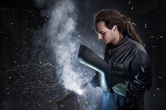 Welder welding with protective equipment