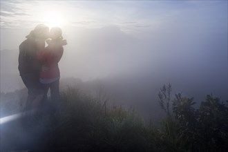 Couple kissing in the fog on the Gunung Agung volcano