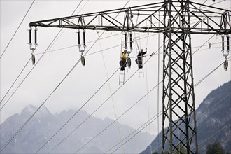 High-voltage service technicians installing a new high voltage power line