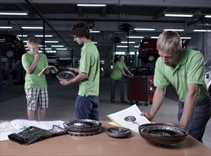 Car mechanic apprentices studying during a training session