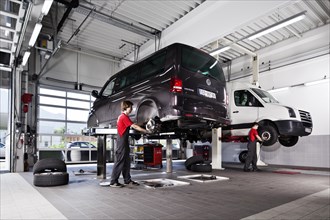 Two VW transporters on car hoists for tyre changes