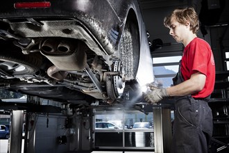 Car mechanic changing tyres in a car repair shop