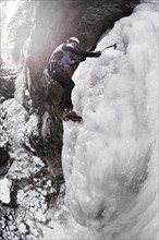 Ice climber climbing a frozen waterfall