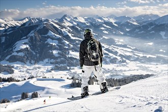 Skier overlooking Wilder Kaiser ski area in the Alps