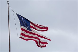 A tattered US-American flag fluttering in the wind