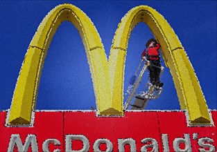 Worker repairing a Golden Arches sign