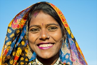 Smiling young woman with a colourful scarf and jewellery