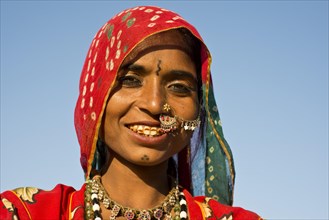 Smiling young Indian woman with a colourful scarf and jewellery