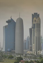 Smog over Corniche waterfront promenade with the skyline of Doha with Al Bidda Tower
