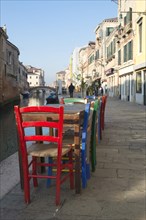 Colourful chairs of a street cafe on the Rio de la Misericordia