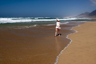 Woman walking along a sandy beach
