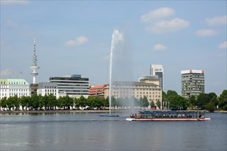 View over the Inner Alster Lake with Alster Fountain and an Alster excursion boat towards the street of Neuer Jungfernstieg