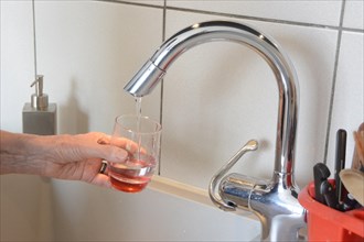 Filling a glass with tap water in a kitchen