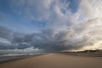 Dramatic cloud formation with rain showers over a North Sea beach