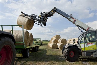 Bales of straw being loaded onto a trailer