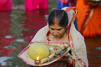 Woman wearing a sari with offerings during the Hindu Chhath Festival