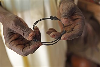 Hands holding a bangle made from elephant tail bristles