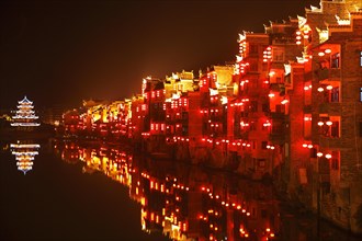 Red illuminated houses on the Wuyang River at night
