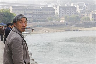 Man smoking a pipe on the Wuyang River