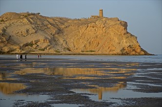 The rocky coast in Al Sawadi at the Gulf of Oman with a tower