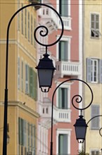 The silhouettes of street lamps in Ajaccio  and the facades of houses in the background. Ajaccio is the capital of the mediterranean island of Corsica