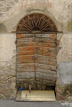 An old wooden door and a decaying facade