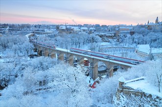 The snowy city of Luxembourg with the aqueduct at dusk