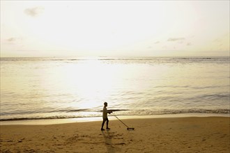 Boy playing on Kribi beach with a homemade toy