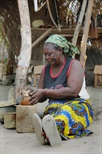 Elderly woman making pottery in front of her stall