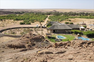 View of the Brandberg White Lady Lodge and the dry river bed of the Ugab river as seen from a hill