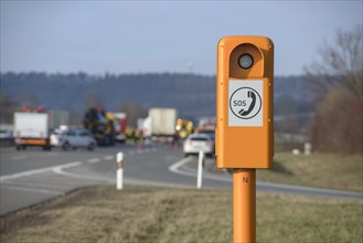 Emergency telephone on the motorway in front of the scene of an accident