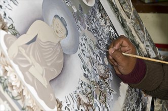 Artist painting a big Thangka in an art school