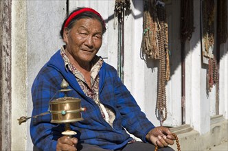 Tibetan pilgrim turning a prayer mill