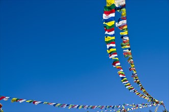 Buddhist prayer flags in front of blue sky above Namche Bazar (3.440 m)