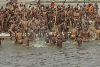 Taking a purifying bath in the river Ganges as part of the initiation of new sadhus at the Sangam