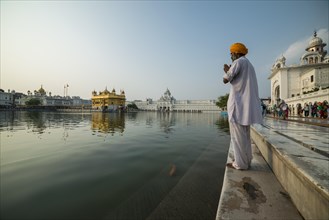A Sikh devotee praying at the holy pool of the Harmandir Sahib or Golden Temple