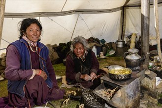 Nomad women preparing food inside their tent