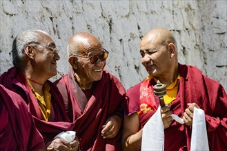 Three monks in the courtyard of Lamayuru Gompa