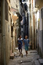 Two boys in a narrow alley in a slum or favela