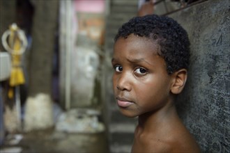 Boy with a suspicious expression in a slum or favela