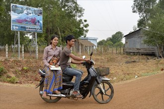 Pregnant young woman travelling with her husband to a rural health center on a motorcycle