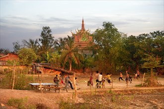 Boys playing football in front of a pagoda